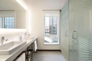 波士顿波士顿酒店的白色的浴室设有2个盥洗盆和淋浴。