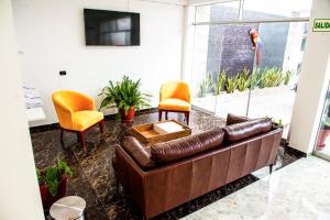 塔拉波托Hotel Boutique Papagayo的客厅配有棕色沙发和两把椅子