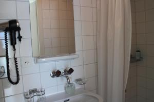 韦吉斯韦吉斯安西塞姆那酒店的浴室配有盥洗盆、淋浴和电话