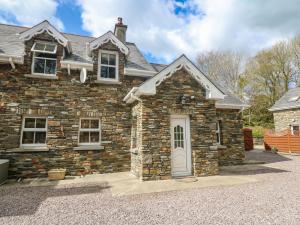 SkahanaghLis-Ardagh Cottage 1的车道上一扇石屋,有白色门