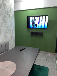 塔里哈Green Space的客厅,在绿色的墙上配有电视