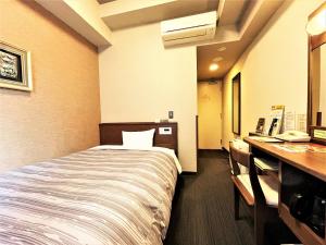 福冈Hotel Route-Inn Hakata Ekimae -Hakataguchi-的配有一张床和一张书桌的酒店客房