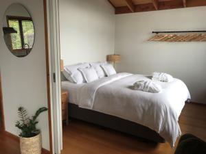 科灵伍德Adrift In Golden Bay- Absolute Beachfront Villas的一间卧室配有一张带白色床单和镜子的床