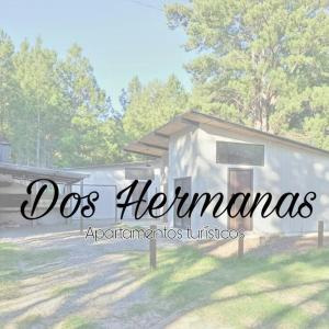 Colonia EstrellaApartamento Dos hermanas的一座白色的小建筑,上面有狗海尼曼的话