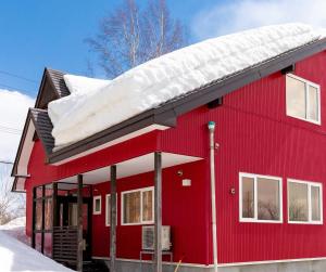 二世古niseko / Vacation STAY 4376的屋顶上积雪的红色房子