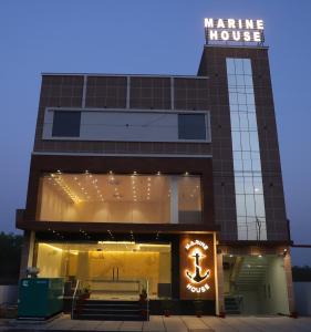 阿格拉Hotel Marine House的一座有海上房屋的建筑,上面有标志