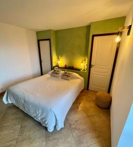 尔萨圣让酒店的卧室设有白色的床和绿色的墙壁