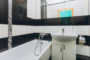 苏梅Перекопская центр люкс квартира посуточно почасово的浴室配有盥洗盆和浴缸。