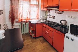 苏梅Перекопская центр люкс квартира посуточно почасово的厨房配有红色橱柜和炉灶烤箱