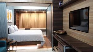 日惹Lavenderbnb Room 2 at Uttara the Icon Apartment的一间卧室配有一张床和一台平面电视
