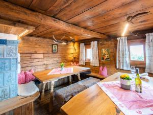 菲根贝格Charming holiday home in Fügenberg with sauna的用餐室设有木墙、木桌和长椅
