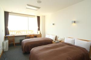 丰浦町Spa SHIOSAI的酒店客房设有两张床和窗户。