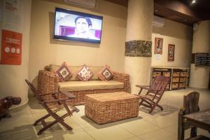 哈博罗内African Home Hotel的客厅配有沙发、椅子和电视
