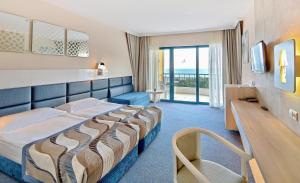 金沙GRIFID Arabella Hotel - Ultra All inclusive & Aquapark的酒店客房设有一张床,享有海景。