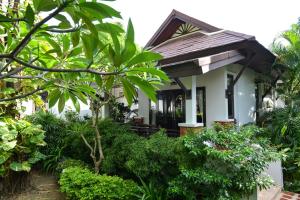 哈林海滩Phangan Bayshore Resort Koh Phangan的一座小白色房子,种有树木和植物