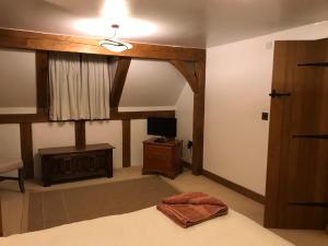 斯塔福德Cosy Cottage in the Countryside的一间卧室配有一张带吊扇的床和一台电视。