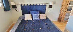 埃姆布能L'HIVERNET, grand Triplex neuf au cœur d'Embrun accès facile的一张带蓝色床单和枕头的床