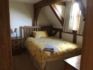 斯塔福德Cosy Cottage in the Countryside的一间卧室配有一张带黄色床单的床和一扇窗户。