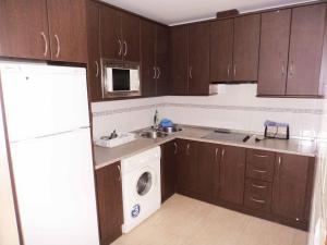 克莉丝蒂娜岛Isladescanso的厨房配有木制橱柜、洗衣机和烘干机