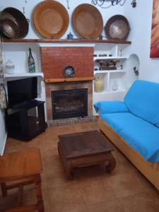 马拉加Casa Rural El Castillo的带沙发和壁炉的客厅