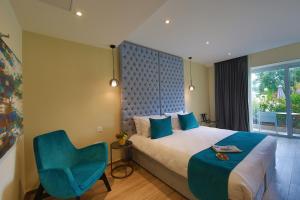 San ĠwannUrban Valley Resort & Spa的一间卧室配有一张床和一张蓝色椅子