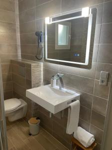 圣安德烈莱韦尔热维拉酒店的一间带水槽、镜子和卫生间的浴室