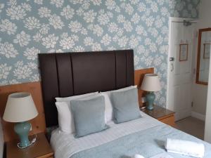 布莱克浦Manchester House的一间卧室配有蓝色和白色壁纸的床