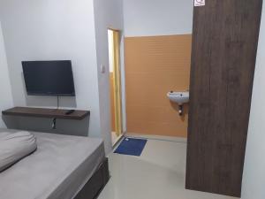 巴淡岛中心Rooms at Josapa Guest House的一间卧室配有一张床、一个水槽和一台电视