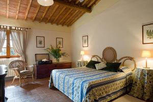 基安蒂格雷夫Fattoria di Rignana的卧室配有一张床和一张桌子及椅子