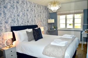 彼得斯菲尔德The Nest Hotel & Restaurant的卧室配有一张白色大床和吊灯。