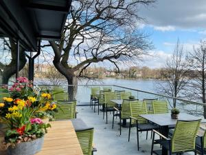 什未林Zweirad Hotel Lenne的一个带桌椅的庭院,毗邻水域
