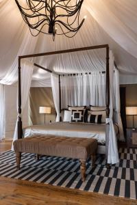 CheyūrThe Alampara Resort的卧室配有一张带地毯的天蓬床