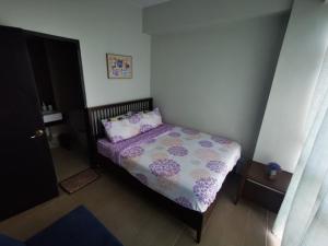 长滩岛New Paradise Ocean View Apartment (DOT accredited)的一间小卧室,配有一张带紫色棉被的床