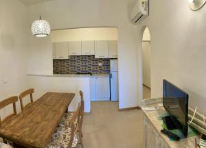 费拉约港Residence Capobianco的一间带木桌的用餐室和一间厨房