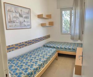 费拉约港Residence Capobianco的客房设有两张床和窗户。
