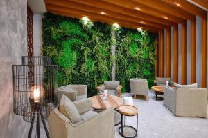 金沙GRIFID Vistamar Hotel - 24 Hours Ultra All inclusive & Private Beach的大堂设有绿墙、椅子和桌子