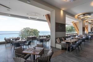 金沙GRIFID Vistamar Hotel - 24 Hours Ultra All inclusive & Private Beach的一间带桌椅的海景餐厅