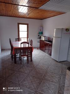 坎波斯杜若尔当Casa Recanto的厨房配有桌椅和冰箱。
