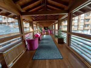 拉兹洛格Airy Studio Pirin Golf Aparthotel & Spa H2A92的一个带粉红色椅子和地毯的空阳台