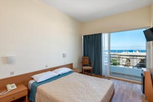 罗德镇赫耳墨斯酒店的一间卧室配有一张床,享有海景