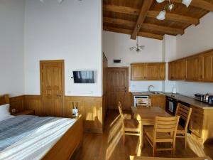 拉兹洛格Airy Studio Pirin Golf Aparthotel & Spa H2A92的一间卧室配有一张床,厨房配有木制橱柜