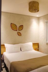 圣米格尔-杜斯米拉格里斯Casa Riacho的卧室配有一张床,墙上有2只蝴蝶