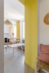 马赛Charmant T3 à proximité du Vieux-Port的客厅设有黄色的墙壁和桌子