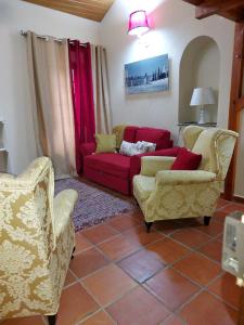 维拉维索萨A Casinha da Vila的客厅配有两把椅子和一张红色沙发