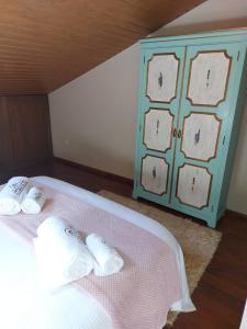 维拉维索萨A Casinha da Vila的一张带两个白色枕头和蓝色橱柜的床