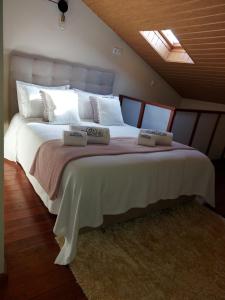 维拉维索萨A Casinha da Vila的一间卧室配有一张大床和两个枕头
