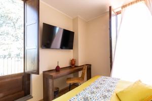 卡迪里翁西塞尔Santoro Country House的一间卧室配有一张床、一张书桌和一台电视。