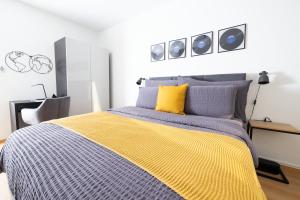 伯尔尼Armotti Pappelweg Bern的一间卧室配有一张黄色和蓝色毯子的床