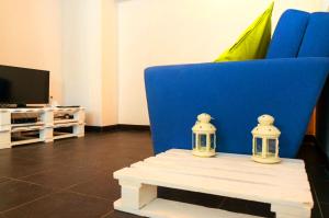 里斯本卡尔尼德度假屋的客厅的一张带两张蜡烛的蓝色椅子