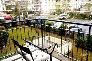 圣朱利安恩因Superbe appartement T2 de 50m2 près de Genève à Saint Julien en Genevois idéal pour couple avec 2 enfants jusqu'à 18 ans的阳台配有桌椅和街道。